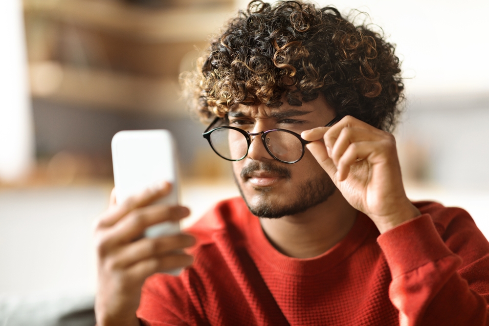 A person who's having difficult time reading on their phone